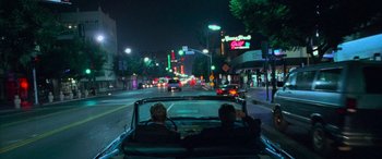 Movie still from “Ocean's Eleven” (2001), directed by Steven Soderbergh – Two people in the back seat of a car driving down a street; Wide shot, High angle