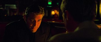 Movie still from “Ocean's Eleven” (2001), directed by Steven Soderbergh – A man sitting in front of another man in a dark room; Close Up shot, Over the shoulder angle