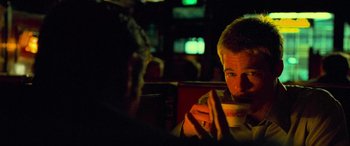 Movie still from “Ocean's Eleven” (2001), directed by Steven Soderbergh – A man sitting at a table holding a bowl of food; Close Up shot, Over the shoulder angle