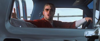 Movie still from “Ocean's Eleven” (2001), directed by Steven Soderbergh – A man in a red jacket driving a blue car; Close Up shot, Low angle