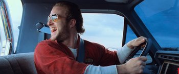 Movie still from “Ocean's Eleven” (2001), directed by Steven Soderbergh – A young man driving a car wearing a red jacket; Close Up shot, Low angle