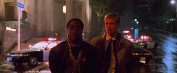 Movie still from “Ocean's Eleven” (2001), directed by Steven Soderbergh – A couple of men standing next to each other on a street; Medium shot, Low angle