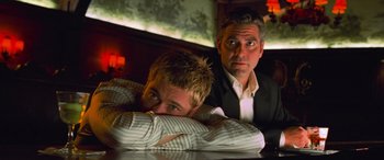 Movie still from “Ocean's Eleven” (2001), directed by Steven Soderbergh – Two men are sitting at a table and one is leaning on his arm; Close Up shot, Low angle