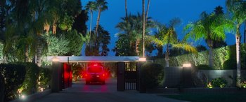 Movie still from “Ocean's Eleven” (2001), directed by Steven Soderbergh – A red car is parked in a driveway under an awning at night; Extreme Wide shot, Low angle