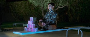 Movie still from “Ocean's Eleven” (2001), directed by Steven Soderbergh – A man sitting on the ground in front of stacks of money; Medium shot, Low angle