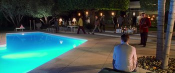Movie still from “Ocean's Eleven” (2001), directed by Steven Soderbergh – A group of people standing around a pool at night; Extreme Wide shot, High angle