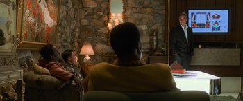 Movie still from “Ocean's Eleven” (2001), directed by Steven Soderbergh – Two people sitting in front of a stone fireplace; Medium shot, Over the shoulder angle
