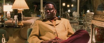 Movie still from “Ocean's Eleven” (2001), directed by Steven Soderbergh – A man in a yellow jacket sitting on a couch; Close Up shot, Low angle