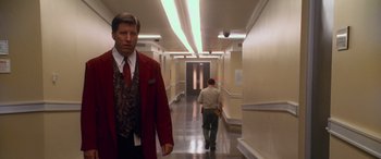 Movie still from “Ocean's Eleven” (2001), directed by Steven Soderbergh – A man in a red jacket is walking down a hall way; Medium shot, Over the shoulder angle