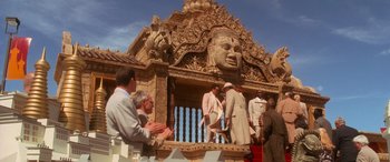 Movie still from “Ocean's Eleven” (2001), directed by Steven Soderbergh – A group of people standing around a building with statues on it; Wide shot, Low angle