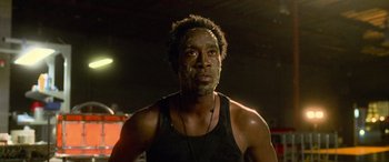 Movie still from “Ocean's Eleven” (2001), directed by Steven Soderbergh – A man in a black tank top is looking at the camera; Close Up shot, Low angle