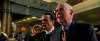 Movie still from “Ocean's Eleven” (2001), directed by Steven Soderbergh – Two men in suits and ties one smoking a cigarette and the other wearing a suit; Close Up shot, Low angle