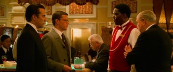 Movie still from “Ocean's Eleven” (2001), directed by Steven Soderbergh – Three men in suits are standing in a room; Medium shot, Over the shoulder angle