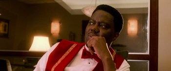 Movie still from “Ocean's Eleven” (2001), directed by Steven Soderbergh – A man wearing a red vest and bow tie; Close Up shot, Over the shoulder angle