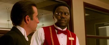 Movie still from “Ocean's Eleven” (2001), directed by Steven Soderbergh – A man wearing a red vest and a red bow tie standing next to another man wearing a red vest; Close Up shot, Over the shoulder angle