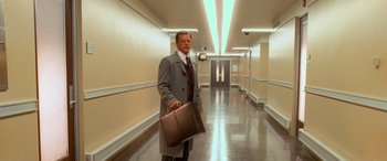 Movie still from “Ocean's Eleven” (2001), directed by Steven Soderbergh – A man holding a briefcase while standing in a hallway; Wide shot, Low angle