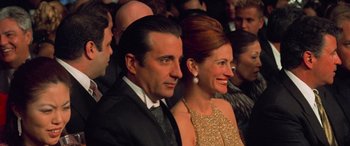 Movie still from “Ocean's Eleven” (2001), directed by Steven Soderbergh – A man and a woman sitting next to each other in a crowd; Medium shot, Low angle