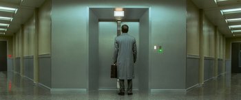 Movie still from “Ocean's Eleven” (2001), directed by Steven Soderbergh – A man in a suit and tie holding a briefcase in an elevator; Wide shot, Low angle