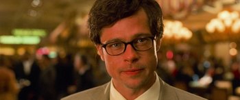 Movie still from “Ocean's Eleven” (2001), directed by Steven Soderbergh – A person wearing glasses and a suit; Close Up shot, Over the shoulder angle