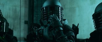 Movie still from “Ocean's Eleven” (2001), directed by Steven Soderbergh – A person wearing a metal helmet and gloves on their head; Close Up shot, Over the shoulder angle