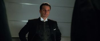 Movie still from “Ocean's Eleven” (2001), directed by Steven Soderbergh – A man in a suit and tie standing in front of a wall; Medium shot, Low angle