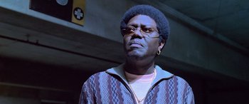 Movie still from “Ocean's Thirteen” (2007), directed by Steven Soderbergh – A man in a sweater and glasses looking to his left; Close Up shot, Low angle