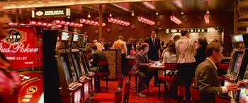 Movie still from “Ocean's Thirteen” (2007), directed by Steven Soderbergh – A group of people sitting at tables in a room; Extreme Wide shot, High angle