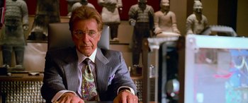 Movie still from “Ocean's Thirteen” (2007), directed by Steven Soderbergh – An older man sitting at a desk in front of statues; Medium shot, Over the shoulder angle
