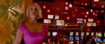 Movie still from “Ocean's Thirteen” (2007), directed by Steven Soderbergh – A woman in a pink dress is holding a cell phone; Medium shot, Low angle