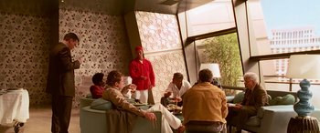 Movie still from “Ocean's Thirteen” (2007), directed by Steven Soderbergh – A group of people sitting at a table eating food; Wide shot, Over the shoulder angle