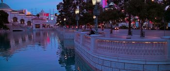 Movie still from “Ocean's Thirteen” (2007), directed by Steven Soderbergh – A man sitting on a bench next to a body of water; Extreme Wide shot, High angle