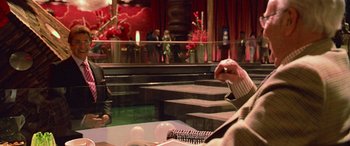 Movie still from “Ocean's Thirteen” (2007), directed by Steven Soderbergh – Two people sitting at a table in front of a stage; Medium shot, Over the shoulder angle