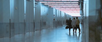 Movie still from “Ocean's Thirteen” (2007), directed by Steven Soderbergh – A man walking down a hallway with two suitcases; Extreme Wide shot, High angle