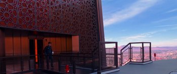 Movie still from “Ocean's Thirteen” (2007), directed by Steven Soderbergh – A person walking on a red fire hydrant next to a building; Extreme Wide shot, Low angle