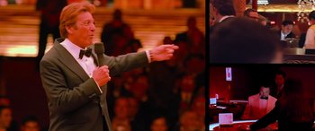 Movie still from “Ocean's Thirteen” (2007), directed by Steven Soderbergh – A man in a gray suit is giving a speech; Medium shot, Over the shoulder angle