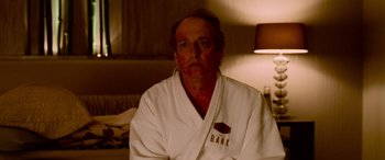 Movie still from “Ocean's Thirteen” (2007), directed by Steven Soderbergh – A man in a white bathrobe sitting on a bed; Close Up shot, Over the shoulder angle