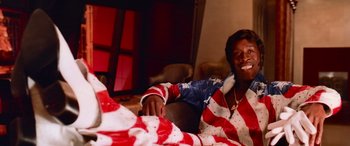 Movie still from “Ocean's Thirteen” (2007), directed by Steven Soderbergh – A man sitting on a couch in a living room; Medium shot, Low angle