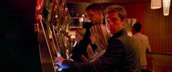 Movie still from “Ocean's Thirteen” (2007), directed by Steven Soderbergh – A man and two women playing a slot machine; Close Up shot, Low angle