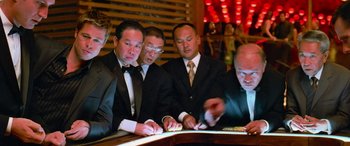Movie still from “Ocean's Thirteen” (2007), directed by Steven Soderbergh – A group of men sitting around a table at a bar; Medium shot, Low angle