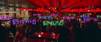 Movie still from “Ocean's Thirteen” (2007), directed by Steven Soderbergh – A group of people standing around a room with neon signs; Wide shot, Over the shoulder angle