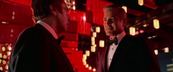 Movie still from “Ocean's Thirteen” (2007), directed by Steven Soderbergh – A man in a suit and a tie standing next to another man in a suit; Medium shot, Over the shoulder angle