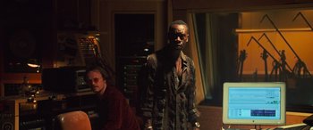 Movie still from “Ocean's Twelve” (2004), directed by Steven Soderbergh – A man standing next to another man in front of a computer screen; Medium shot, Low angle