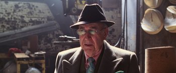 Movie still from “Ocean's Twelve” (2004), directed by Steven Soderbergh – An older man wearing a hat and glasses; Close Up shot, Over the shoulder angle