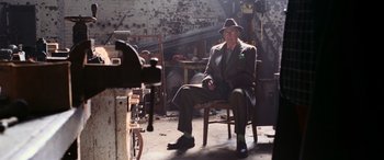 Movie still from “Ocean's Twelve” (2004), directed by Steven Soderbergh – An older man sitting in a chair wearing a hat; Wide shot, Low angle