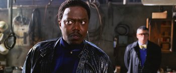 Movie still from “Ocean's Twelve” (2004), directed by Steven Soderbergh – A man in a blue shirt and a leather jacket; Close Up shot, Low angle