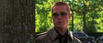 Movie still from “Ocean's Twelve” (2004), directed by Steven Soderbergh – A person wearing sunglasses near a tree; Close Up shot, Over the shoulder angle