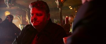 Movie still from “Ocean's Twelve” (2004), directed by Steven Soderbergh – A person sitting at a table in a restaurant; Close Up shot, Over the shoulder angle