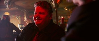 Movie still from “Ocean's Twelve” (2004), directed by Steven Soderbergh – A person sitting in a room; Close Up shot, Over the shoulder angle