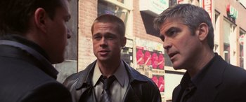 Movie still from “Ocean's Twelve” (2004), directed by Steven Soderbergh – A man in a leather jacket standing next to another man in a tie; Close Up shot, Over the shoulder angle