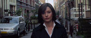 Movie still from “Ocean's Twelve” (2004), directed by Steven Soderbergh – A woman in a black jacket standing on the sidewalk; Close Up shot, Low angle